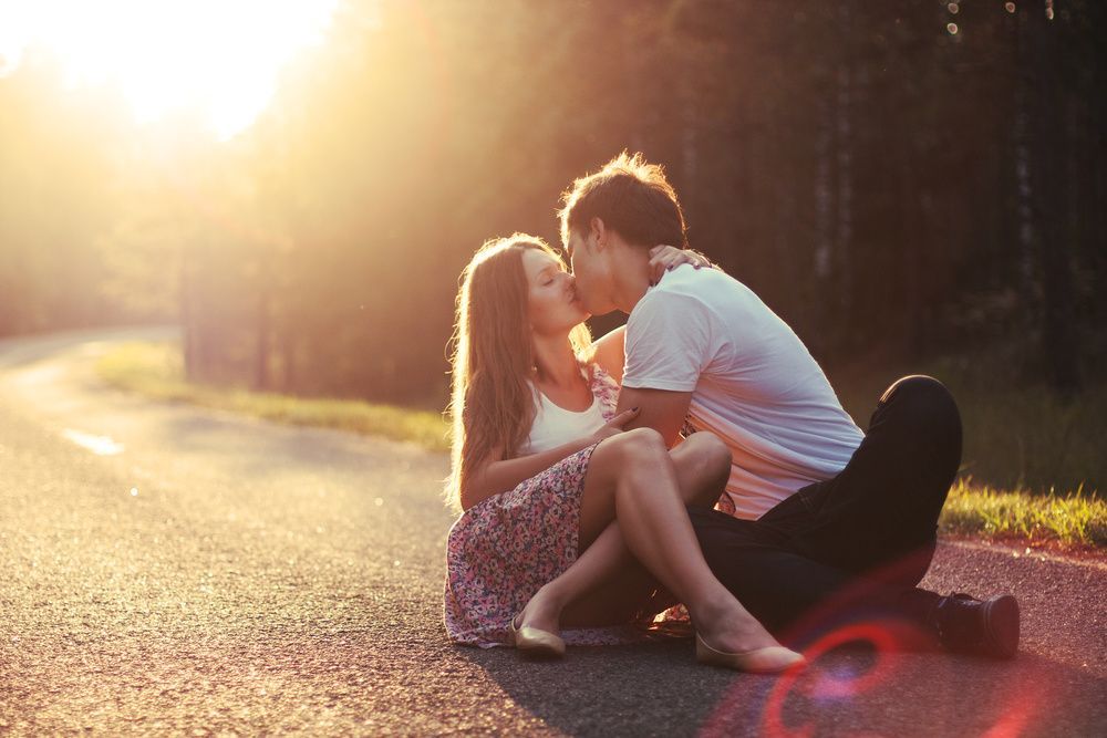 jovem casal se beijando na natureza, luz do sol, primeiro amor