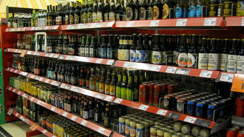 Prateleiras de mercearias cheias de garrafas de cerveja.