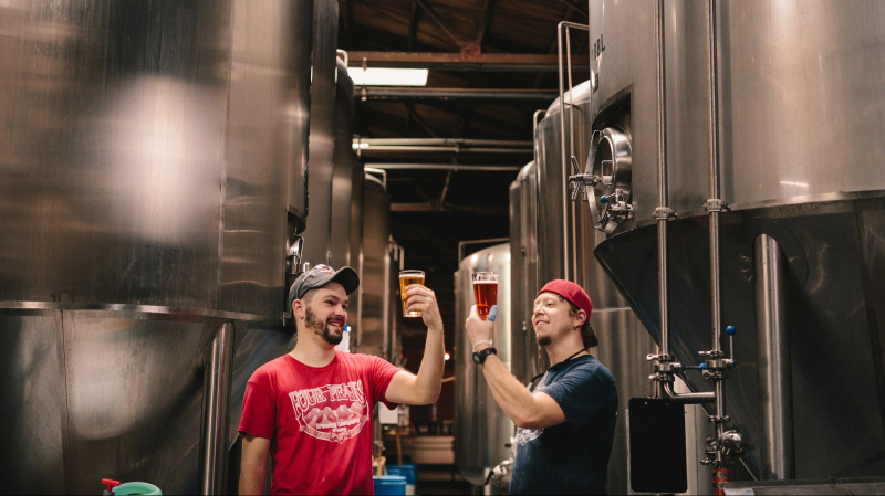 Dois cervejeiros analisam seus últimos lotes de cerveja.